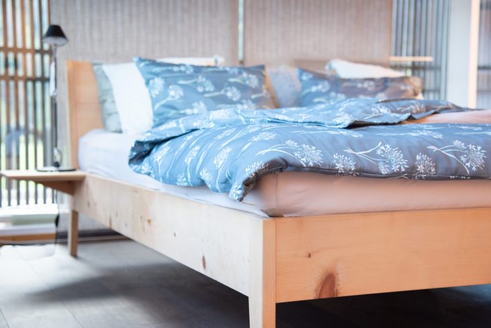 Bettgestell aus Massivholz Arve mit integriertem Nachttisch Bettware und Hüsler Nest Naturbett Inhalt